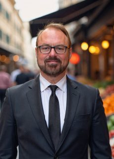 Professional headshot of a smiling employee against a neutral background.